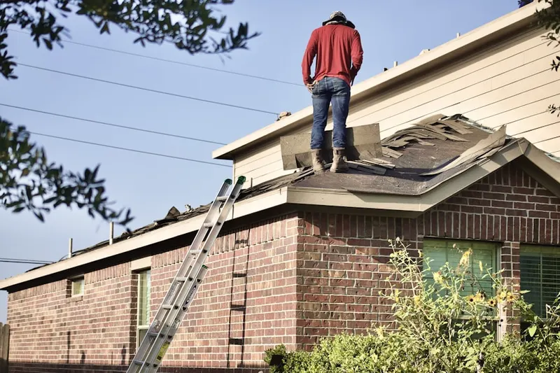 Professional roofer working on a residential roof in Dacono